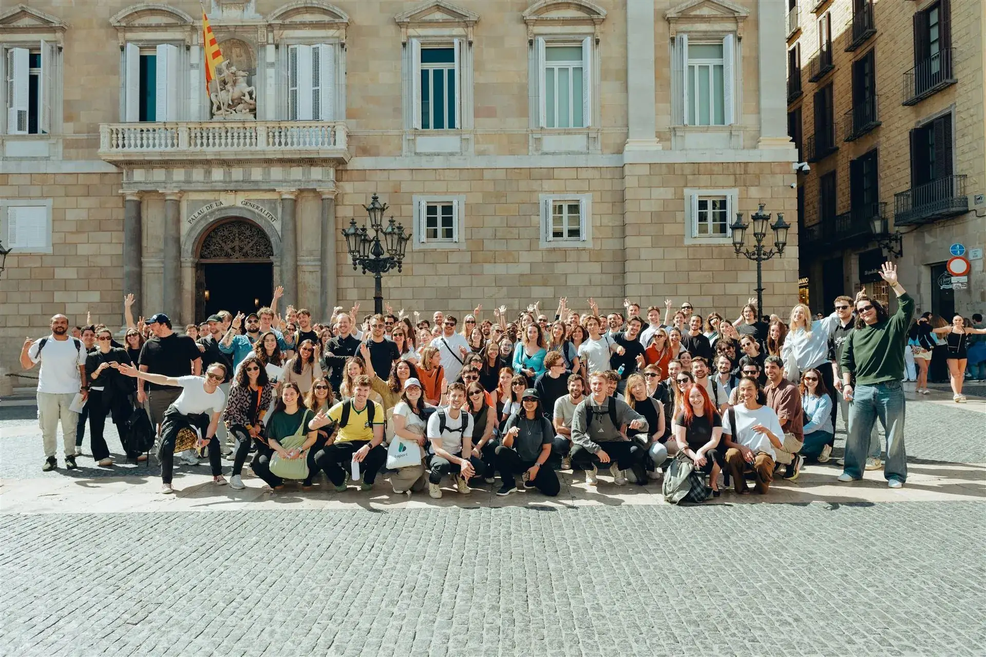 A large corporate group celebrating together in front of the Palau de la Generalitat in Barcelona
