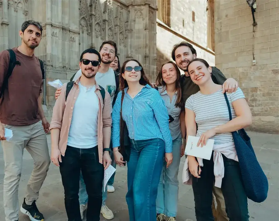 A smiling group posing together in front of Barcelona Cathedral