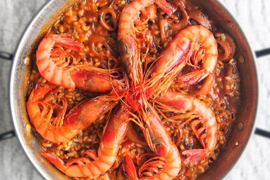 Team cooking a traditional paella together in a Barcelona cuisine workshop