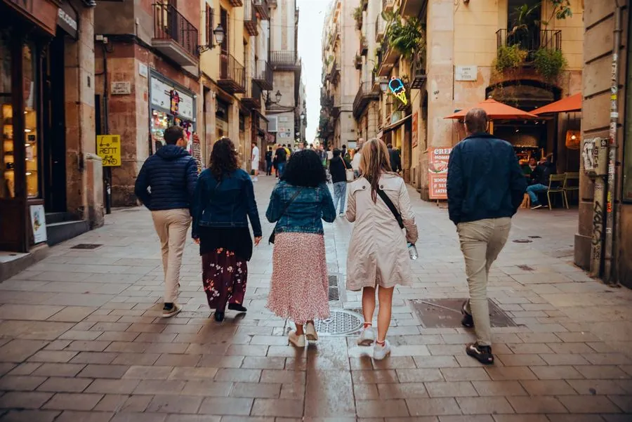 Participants walking through a golden-lit Gothic Quarter street